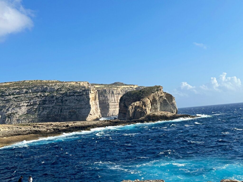 Gozo Malta nhìn từ trên cao với bờ biển hoang sơ, vách đá vàng đặc trưng và làn nước Địa Trung Hải trong xanh.