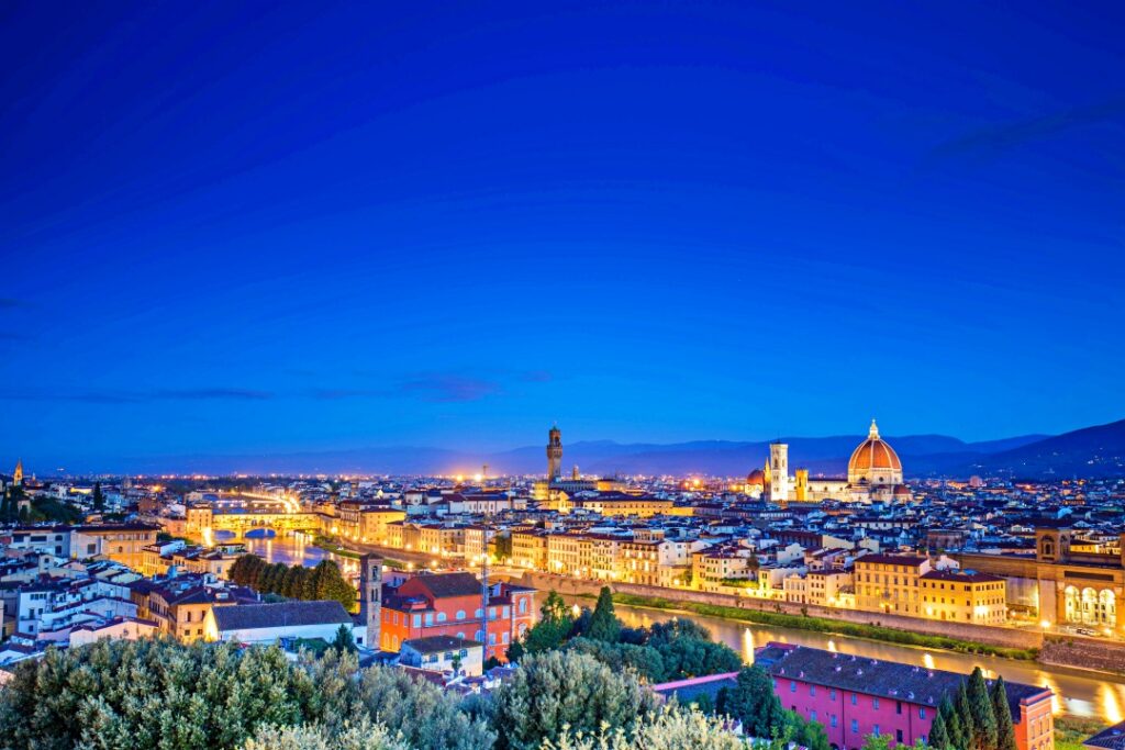 Toàn cảnh Florence từ Piazzale Michelangelo lúc hoàng hôn, mái ngói đỏ và Duomo rực sáng trong ánh vàng Tuscany