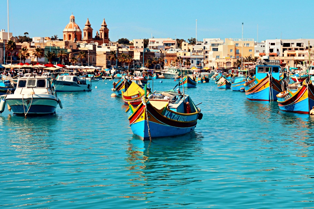 Làng chài Marsaxlokk Malta với thuyền Luzzu đầy màu sắc và mắt Osiris trên mũi thuyền – trải nghiệm du lịch Malta gần gũi và truyền thống.